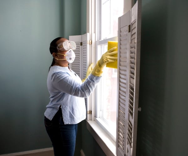 Professional house cleaner tidying a bright, freshly cleaned living room